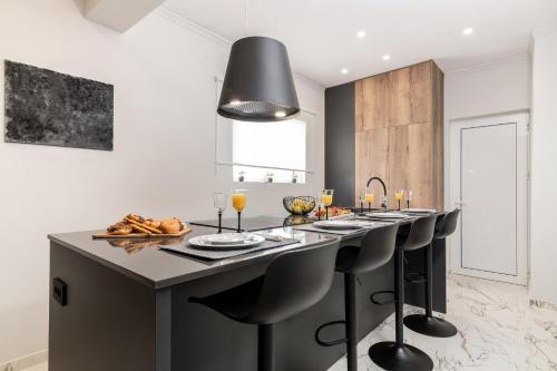 una cocina con una gran isla con taburetes negros en Villa Merlis, en Kalamaki