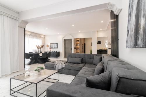 Una sala de estar con un sofá grande y una mesa. en Villa Merlis, en Kalamaki