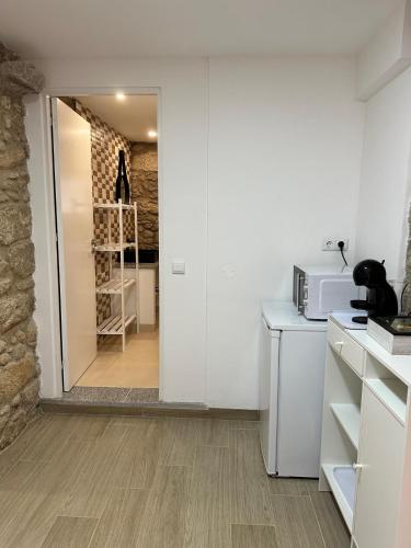 a kitchen with white walls and a counter with a microwave at Forno House - Quarto peregrinos Caminho Santiago in Âncora