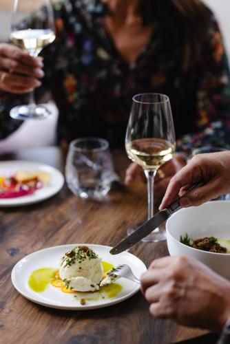a woman sitting at a table with a plate of food at Rössli Hurden in Hurden