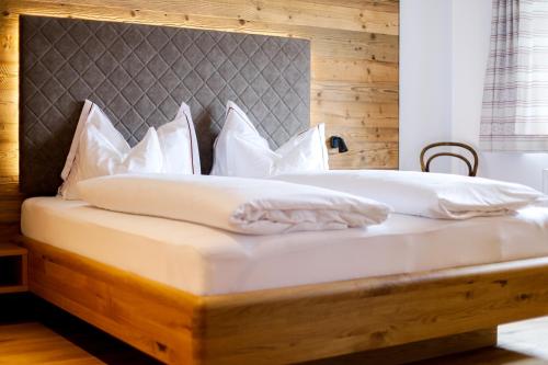 a bed with white pillows and a wooden headboard at Gasthof Adler in Doren