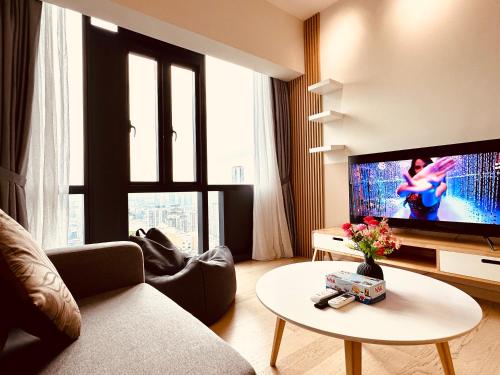 a living room with a couch and a tv and a table at Star Residence Suite KLCC in Kuala Lumpur