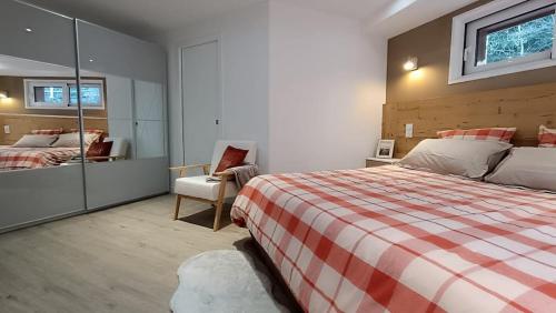 une chambre avec un lit, une chaise et un miroir dans l'établissement Beau T2 refait à neuf, à Brides-les-Bains