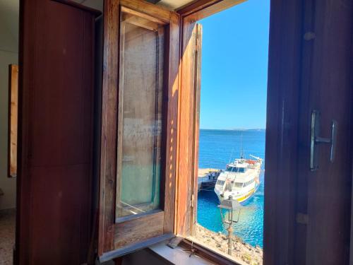 a window with a view of a boat in the water at Seaview Levanzo in Levanzo