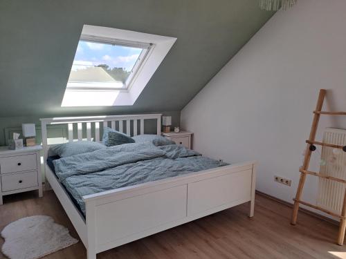 ein Schlafzimmer mit einem weißen Bett und einem Fenster in der Unterkunft Ferienwohnug mit Balkon und Carport in Dülmen