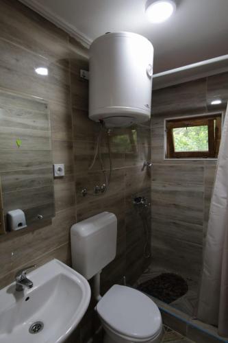 a bathroom with a white toilet and a sink at Rafting kamp Ivona in Foča