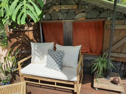 a chair on a patio with pillows on it at Les bungalows de la kazouale in Saint-Leu