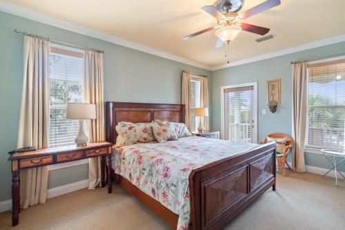 Un dormitorio con una cama y una mesa y ventanas. en Mandevilla, en Gulf Shores