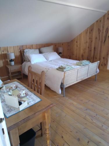 une chambre avec un grand lit et une table dans l'établissement LES DAMES DE LA SAUGIAT, à Le Fied