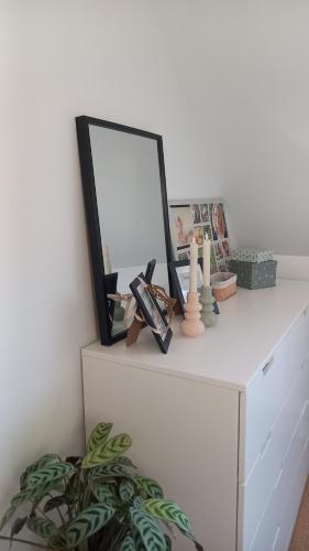 a white dresser with a mirror and a plant at Chambre Vert Sauge, lit double 2 personnes, Maison en plein coeur du Parc Régional du Vexin in Hérouville