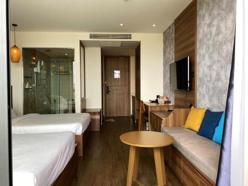a hotel room with two beds and a couch at APEC MANDALA Tuy Hòa in Liên Trì (4)
