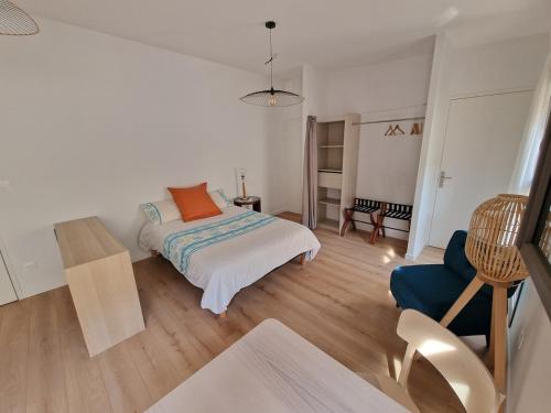 une chambre avec un lit et une chaise bleue dans l'établissement Studio neuf climatisé wifi 27m2, à Oullins