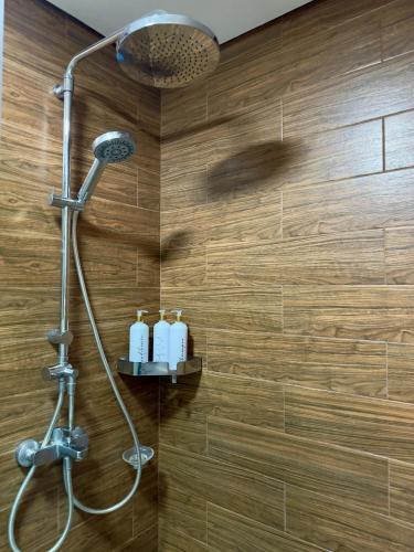a bathroom with a shower with two bottles of soap at Bayfront 1BR Condo in Pasay Manila with Wi-Fi, Netflix & Pool Access, Near NAIA Airport, Mall of Asia, OKADA, CCP & PICC in Manila