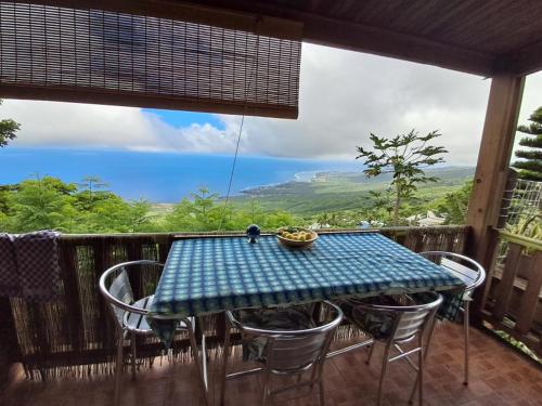 a table and chairs on a deck with a view at Les bungalows de la kazouale in Saint-Leu