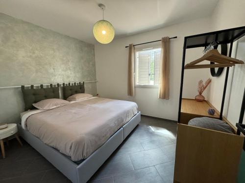 une chambre avec un grand lit et une fenêtre dans l'établissement Maison L 'escapade, à Saint-Julien