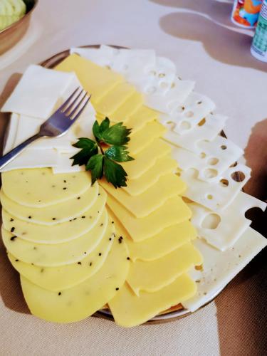 a plate of cheese on a table with a fork at Świat Jezior in Mikołajki