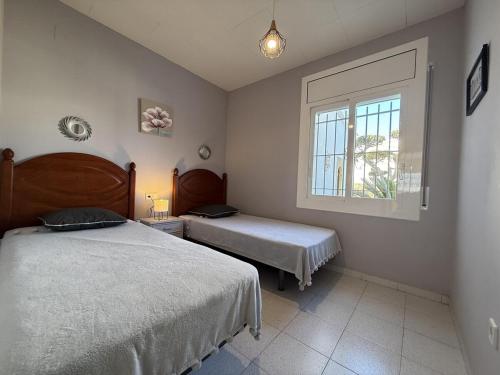 a bedroom with two beds and a window at AwayDays - Casa con Piscina in Empuriabrava