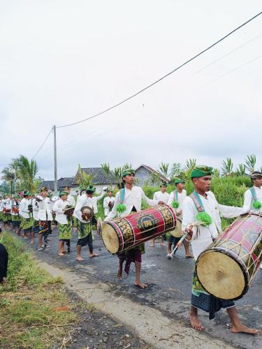 a group of people playing drums in a parade at Raturinjani homestay in Selong