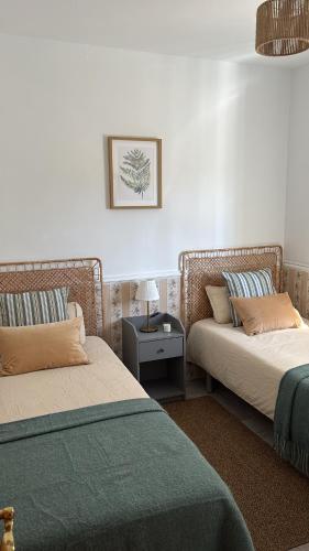a room with two beds and a side table at Casa Paloma Blanca in Málaga