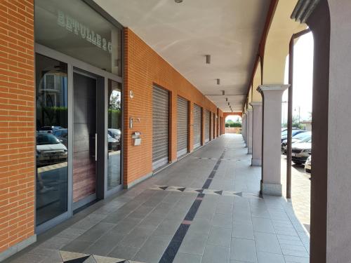 an empty hallway of a building with glass doors at Turin Airport premium apartment G in Leinì