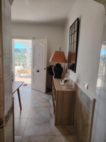 a hallway with a table and a lamp and a door at Casa Paloma Blanca in Málaga