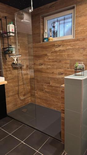 La salle de bains est pourvue d'une douche et d'une télévision murale. dans l'établissement Appartement family, à Taninges