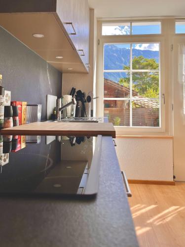 a kitchen with a counter top and a window at Casa Aquila in Ringgenberg