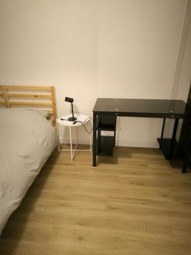 un bureau avec une lampe à côté d'un lit dans l'établissement t2 spacieux proche zénith&aéroport&purpan, à Toulouse