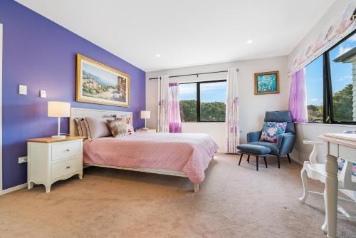 a purple bedroom with a bed and a chair at Auckland Golden Phoenix Holiday Homes in Auckland