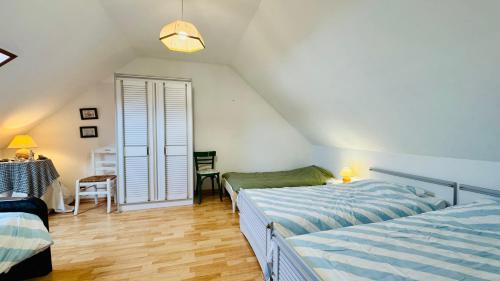 a attic bedroom with two beds and a table at La perle du Nord in Merlimont
