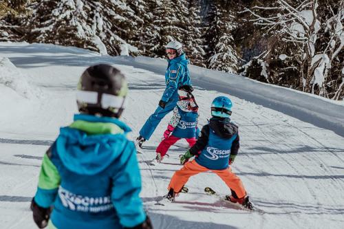 a group of people skiing down a snow covered slope at Österreichischer Hof-im Bademantel direkt in die Alpentherme in Bad Hofgastein