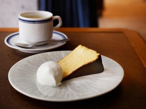 a piece of cake on a plate next to a cup of coffee at Southwest Grand Hotel in Naha