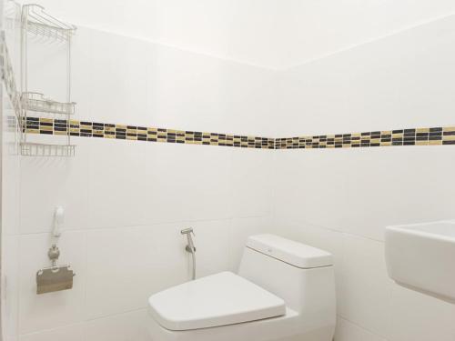 a white bathroom with a toilet and a sink at Sukhumvit 81 Haven House- BTS Onnut in Bangkok