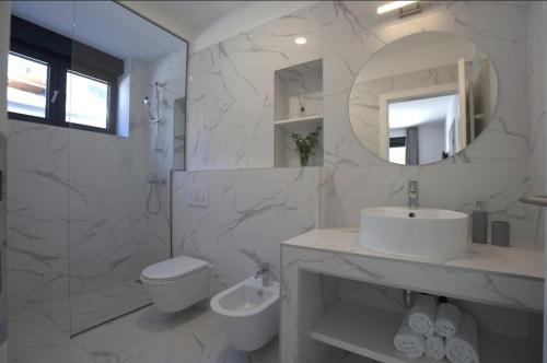 a bathroom with a sink and a toilet and a mirror at Luxury Villa Mandy - Split in Žrnovnica