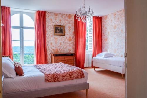 - une chambre avec 2 lits et une fenêtre avec des rideaux rouges dans l'établissement Superbe Château du 19eme en Touraine 15 p, à Saint-Patrice
