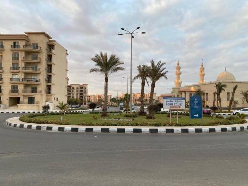 a roundabout in a city with palm trees and a mosque at Sokón Residence - Cairo-New Cairo-Madinaty B7 in New cairo
