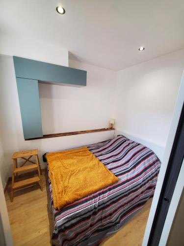 une chambre avec un lit avec une couverture dessus dans l'établissement Appartement bord de mer, à Argelès-sur-Mer