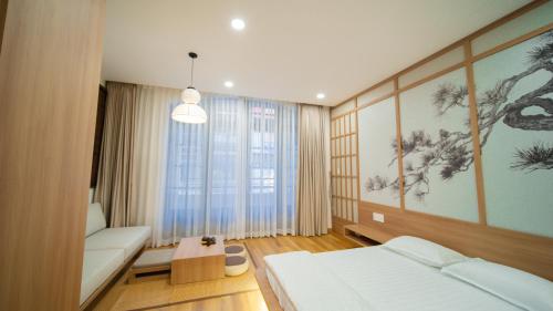 a bedroom with a bed and a couch and a table at Katoya Suites Saigon Honkan 加藤部屋西貢本館 in Ho Chi Minh City