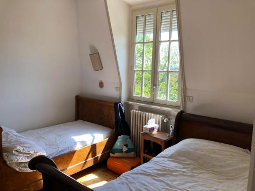 une chambre avec deux lits et une fenêtre dans l'établissement Grande villa maritime à Perros-Guirec - Vue mer - Proche plage, à Perros-Guirec