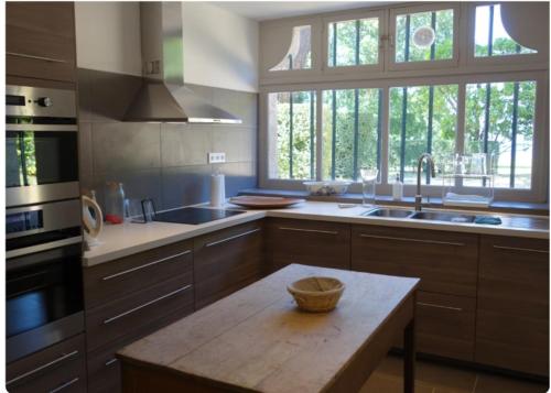 - une cuisine avec une table en bois dans l'établissement Grande villa maritime à Perros-Guirec - Vue mer - Proche plage, à Perros-Guirec