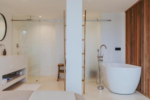 a bathroom with a tub and a glass shower at The Hotel in Ahangama