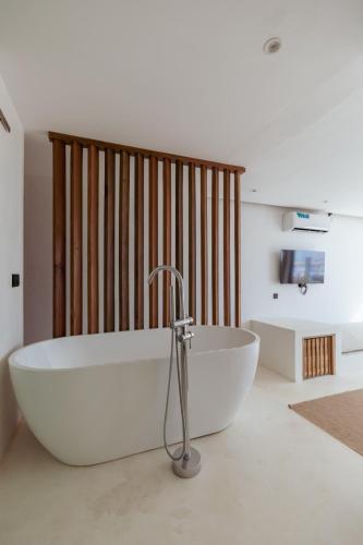a large white bath tub in a room with a sink at The Hotel in Ahangama