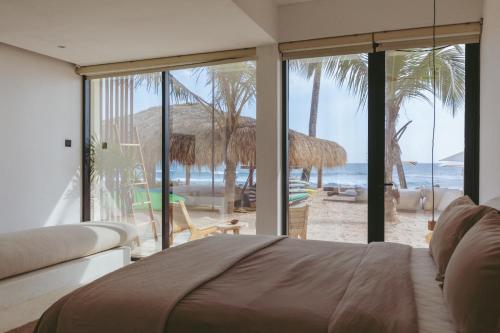 a bedroom with a bed and a view of the beach at The Hotel in Ahangama