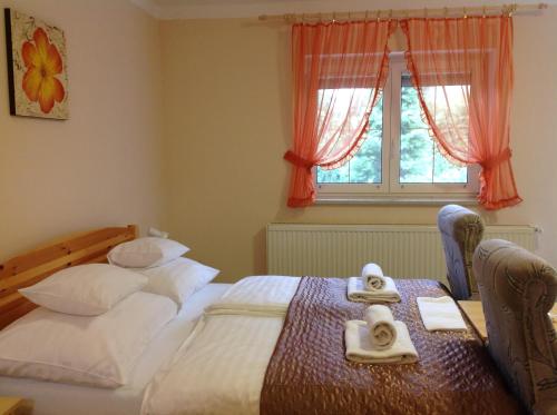 ヘーヴィーズにあるHonvéd Apartmanházのベッドルーム1室(ベッド2台、タオル付)