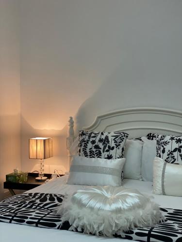 a white bed with black and white pillows at Campbeltown Private Room in Campbelltown South