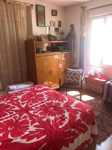 - une chambre avec un lit rouge et blanc et une fenêtre dans l'établissement Joli deux pièces bien decores, à Malakoff