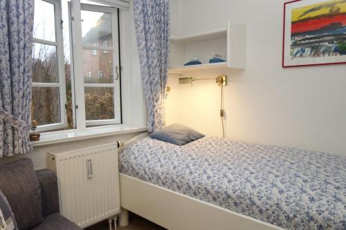 Un dormitorio pequeño con una cama y una ventana. en Sonnenblume, en Oevenum