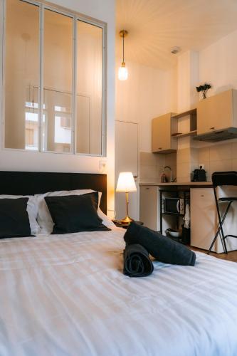 - une chambre avec un lit blanc et un chapeau dans l'établissement L 'Haussmannien - Chic - Gare - Metro - Centre, à Toulouse