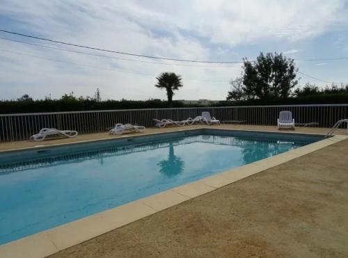 une piscine avec des chaises et une clôture dans l'établissement Les terrasses de la piscine, à Agde