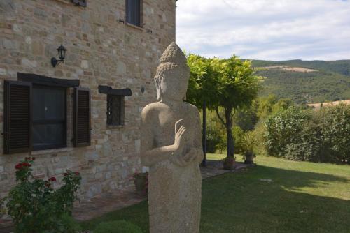 a statue of a woman standing in front of a building at Casa Anandi Retreat in Santa Maria di Paterno